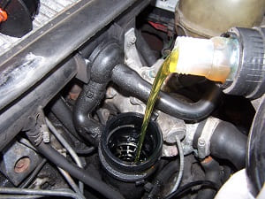 Pouring engine oil into car engine