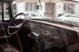 Interior view of a vintage car dashboard and steering wheel.