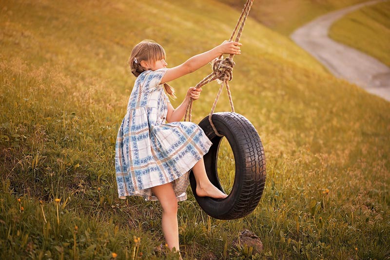 A girl playing with swing tire.