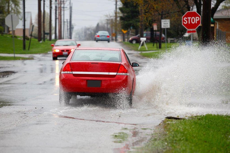 A red car splashing water