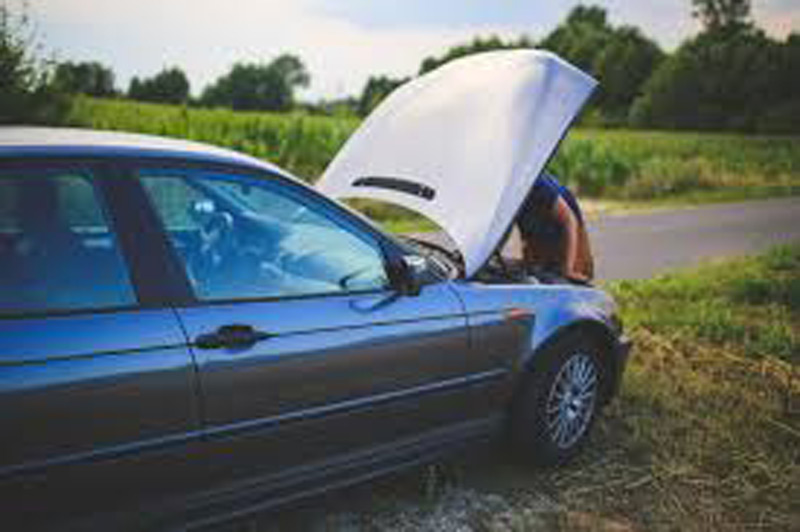 A mechanic repairing the car from the front.