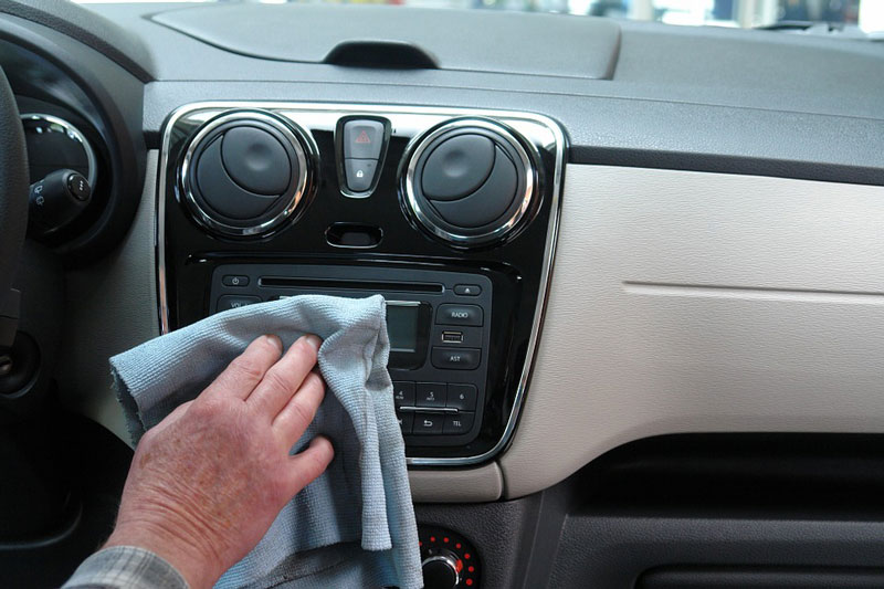 A man cleaning car stereo.