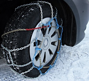 Car tire chained securely parked on a snowy road