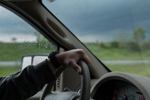 a person holding a car steering wheel