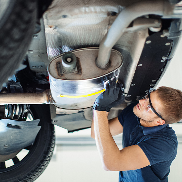Closeup low angle view of a young man cleaning lower section of a car