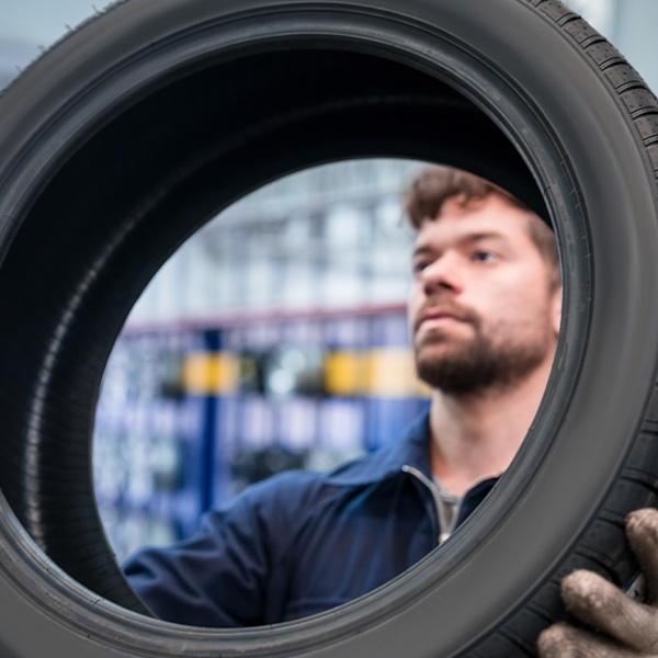 Car mechanic checking tire