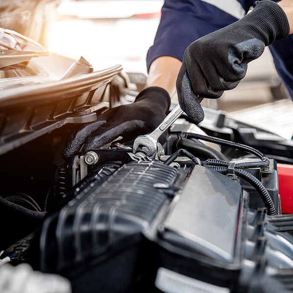 Close-up hand technician auto mechanic using the wrench