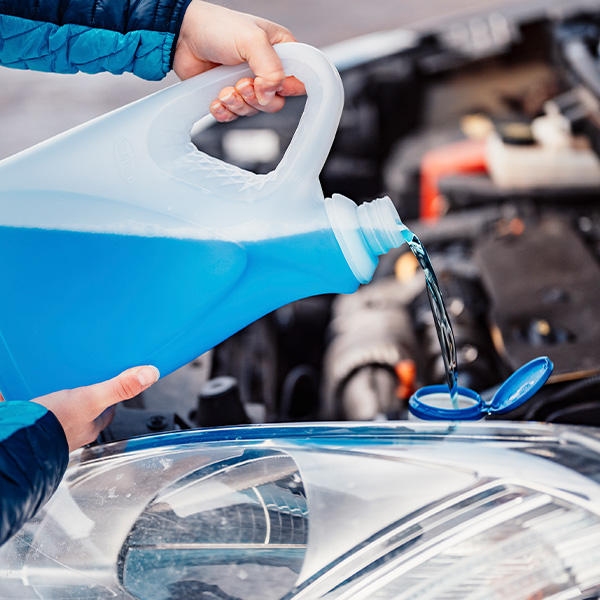 Filling a windshield washer tank with an antifreeze in winter cold weather
