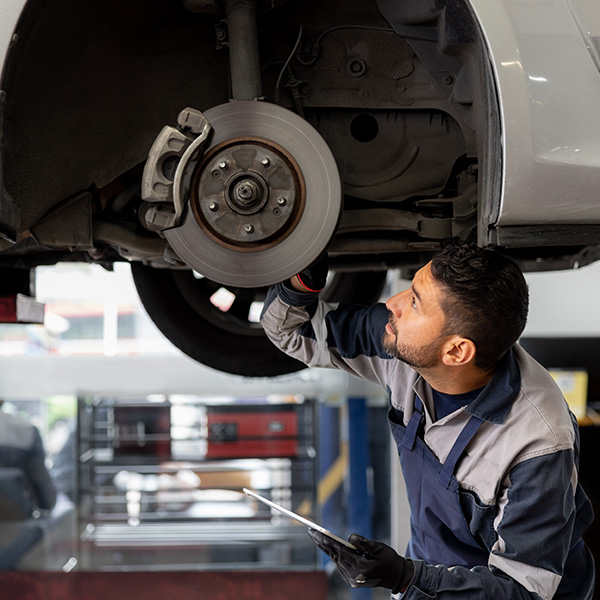Mechanic aligning a car tire at an auto repair shop