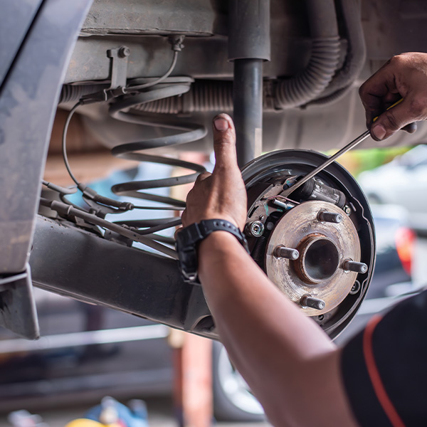 Mechanic works on the brake system of a vehicle in a garage