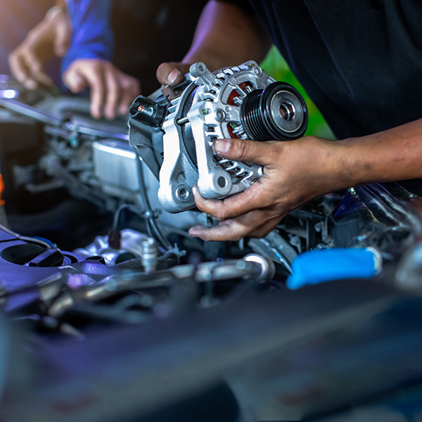 Mechanic is repairing and replacing a battery charger at car service center