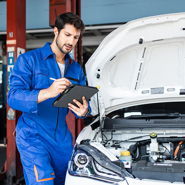 Mechanic engineer man in uniform works with broken electric car