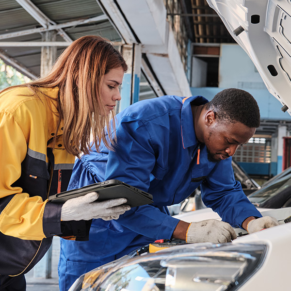 The mechanic's coworkers check the EV car in the service garage