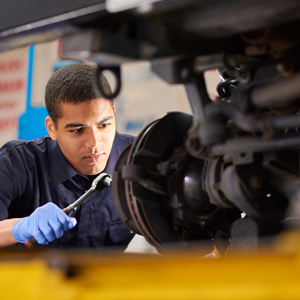 Mechanic is working on a car in a garage repair shop