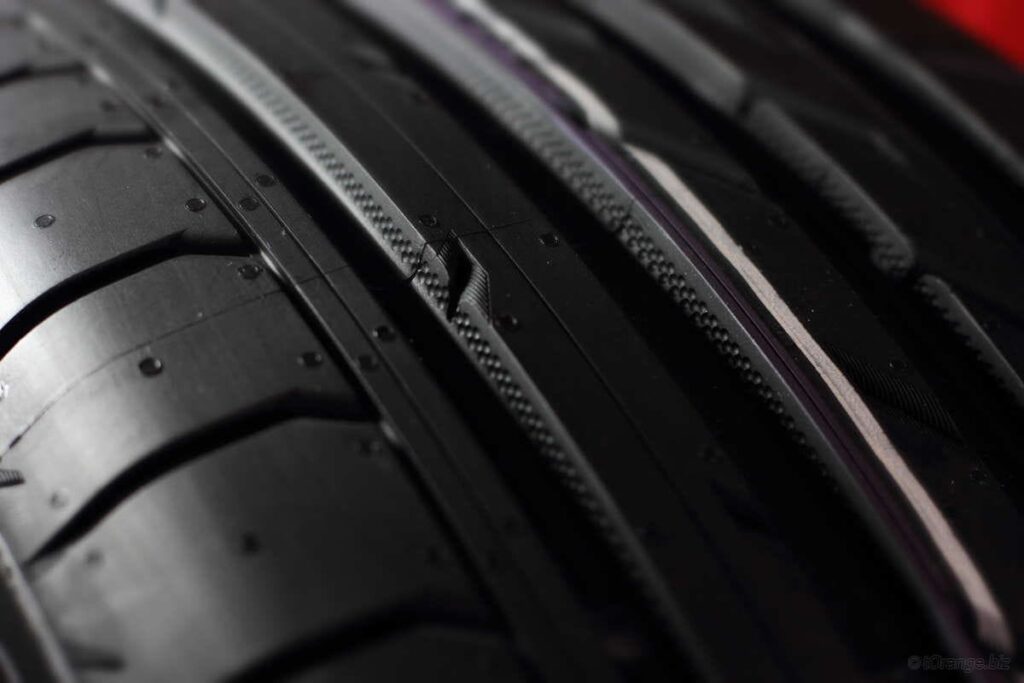 Close-up of a car tire showing detailed tread pattern and grooves for traction.