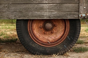 Close-up of a rusted wheel on a wooden trailer