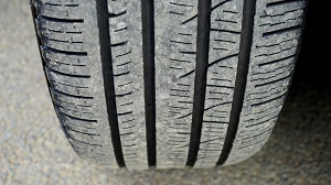 Close-up of a car tire showing worn tread pattern